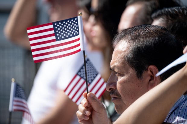 Citizenship candidate Victor Martinez holds his flag during Citizenship ceremony...