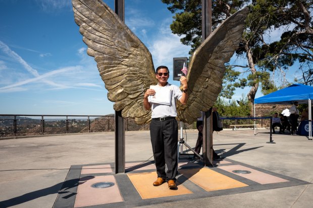 New U.S. Citizen Felix Tapongot poses for a photo after...