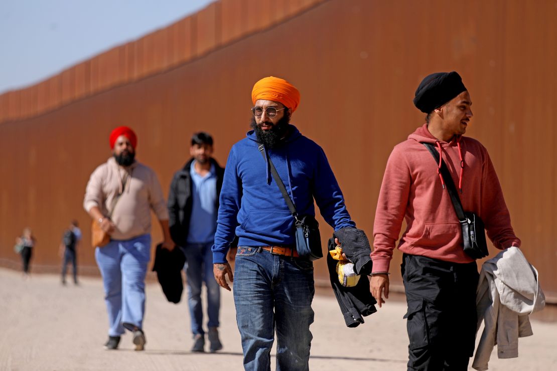 SAN LUIS COLORADO, SONORA - MAY 11: Immigrants from India walk along the border wall to turn themselves over to U.S Border Patrol agents along the U.S.-Mexico border on Thursday, May 11, 2023 in San Luis Colorado, Sonora. Title 42, a pandemic-era policy that allowed border agents to quickly turn back migrants, expires this week. Under a new rule, the U.S. on Thursday will begin denying asylum to migrants who show up at the U.S.-Mexico border without first applying online or seeking protection in a country they passed through. (Gary Coronado / Los Angeles Times via Getty Images)