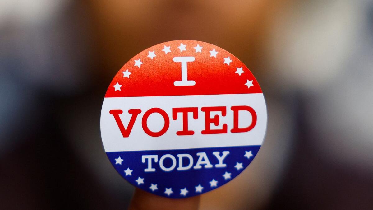 A US citizen abroad voter shows a sticker that reads 'I voted today' at a stand set up outside a cafe by Democrats Abroad volunteers to help Americans living in Paris to navigate the bureaucracies of state and local election laws, in Paris, France, on Monday. REUTERS