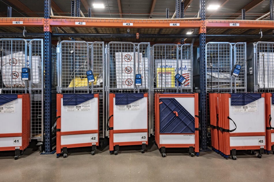 Behind the glass, the boxes used to bring the ballots from the polling stations are sealed with padlocks that can be tracked by satellites.