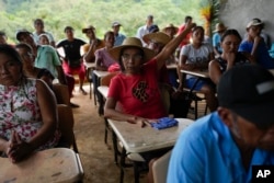 Jeronima Figueroa raises her hand during a meeting with Panama Canal representatives about a proposed project that would dam the Indio River and limit access in her community of El Jobo, Panama, Aug. 31, 2024.