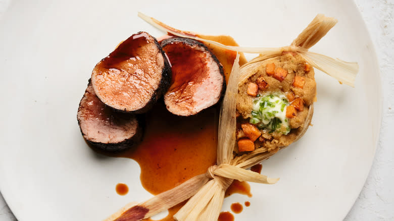 pork tenderloin and tamale on plate