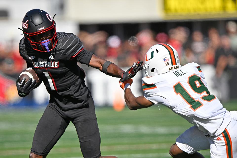 Oct 19, 2024; Louisville, Kentucky, USA; Louisville Cardinals wide receiver Ja'Corey Brooks (1) runs the ball against Miami Hurricanes defensive back D'Yoni Hill (19) during the second half at L&N Federal Credit Union Stadium. Miami defeated Louisville 52-45. Mandatory Credit: Jamie Rhodes-Imagn Images