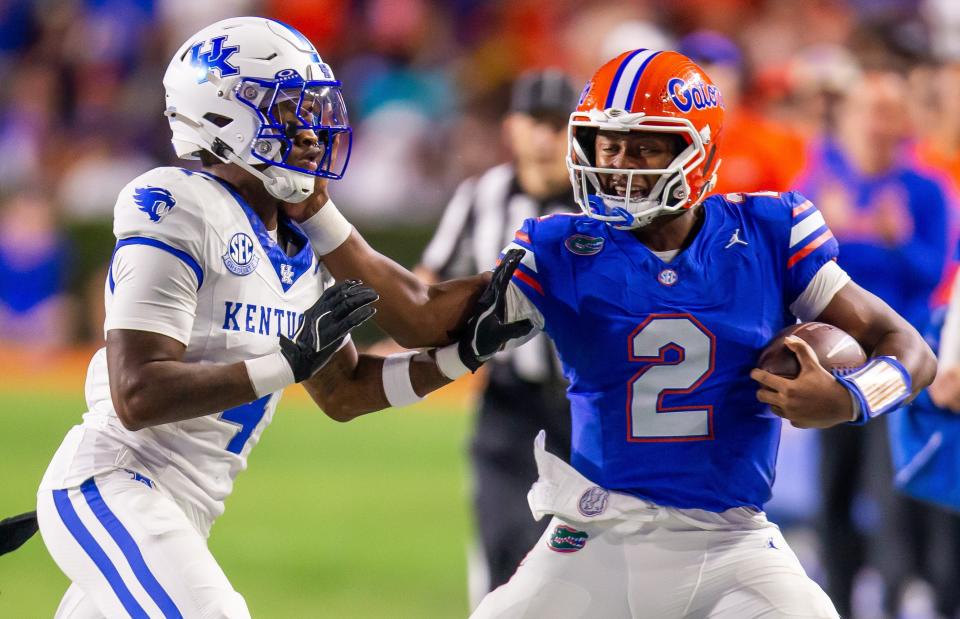 Florida Gators quarterback DJ Lagway (2) stiff arms Kentucky Wildcats defensive back Kristian Story (4) during the first half at Ben Hill Griffin Stadium in Gainesville, FL on Saturday, October 19, 2024 against the Kentucky Wildcats. [Doug Engle/Gainesville Sun]