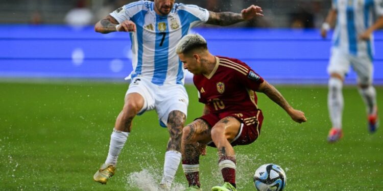Argentina's midfielder Rodrigo De Paul and Venezuela's midfielder Yeferson Soteldo fight for the ball during the 2026 FIFA World Cup South American qualifiers football match between Venezuela and Argentina, at the Monumental de Maturín stadium in Maturín, Venezuela, on October 10, 2024.