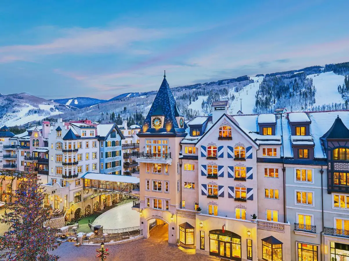 The Arrabelle at Vail Square hotel with snow-covered mountain slopes in the background.