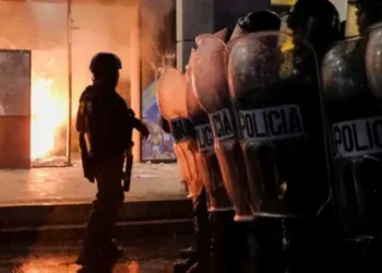 Reuters Riot police officers keep watch after clashing with demonstrators when trying to break blockades, as part of a national strike to demand the resignation of authorities from the attorney general's office, in Guatemala City, Guatemala October 9, 2023