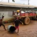 AFP Garbagemen pick up trash in Port Kaituma, Guyana, on September 21, 2022, in front of a garbage truck on a road.
