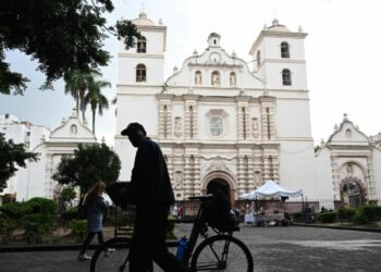 A man walks by on his bicycle in front of the San Miguel Arcangel Cathedral in the historic center of Tegucigalpa.