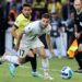 Matias Viña (R), in white kit, takes control of the ball with Rodrigo Paz Delgado, in yellow and black, not far behind, during Uruguay vs Ecuador.