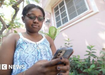 Nun Neethoudjif Méléance pictured staring at an iPhone she's holding