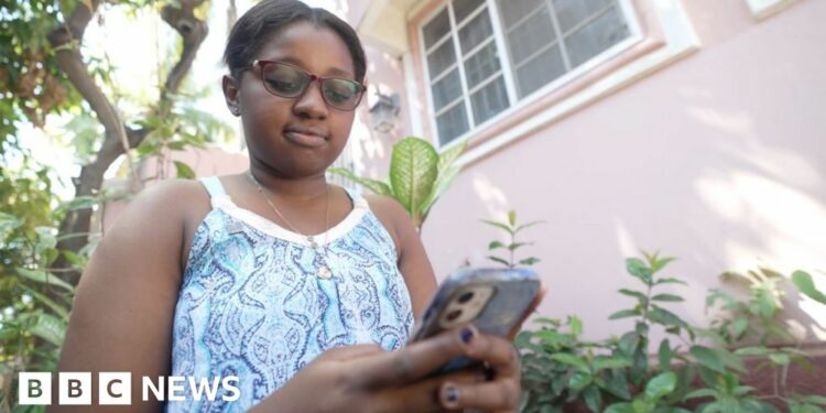 Nun Neethoudjif Méléance pictured staring at an iPhone she's holding