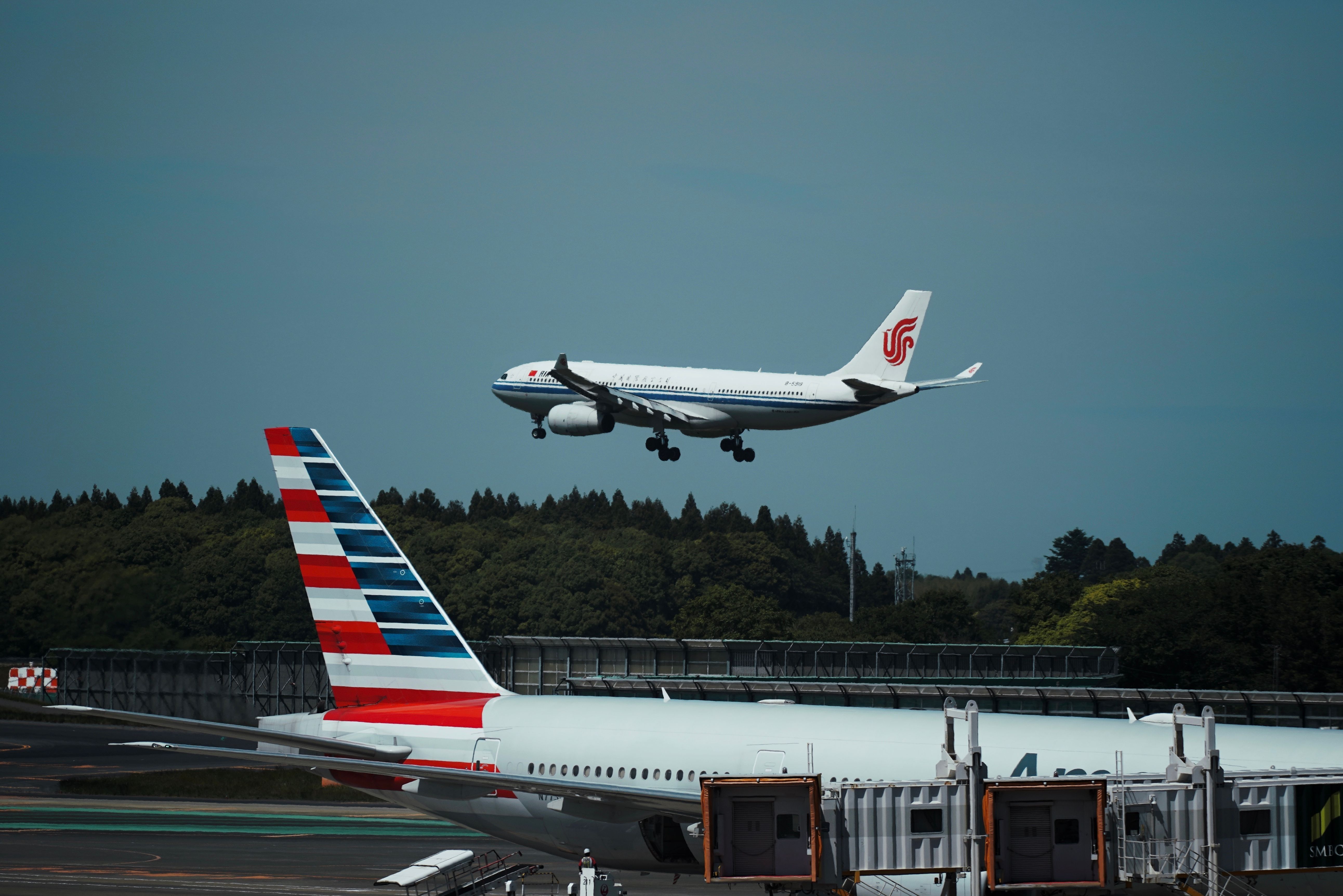 Air China Airbus A330 landing with an American Airlines aircraft in the foreground shutterstock_2417007465