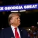 Trump at his rally in Georgia stood under a sign that says