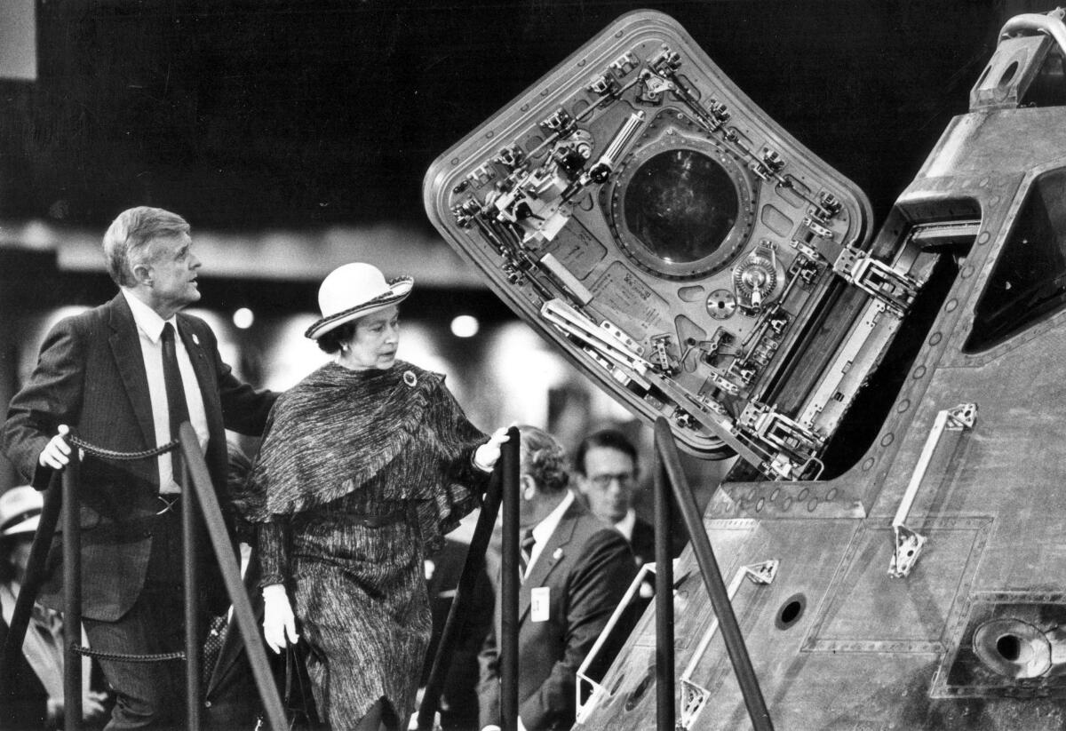 Queen Elizabeth II looks at the Apollo space capsule 