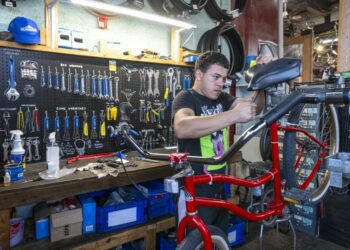 Francesco Ramon, a Venezuelan migrant who’s been working as a bike technician since June, works on a bike at one three workshops at Working Bikes located in Little Village, Wednesday, Oct. 9, 2024.