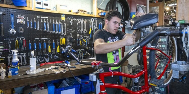 Francesco Ramon, a Venezuelan migrant who’s been working as a bike technician since June, works on a bike at one three workshops at Working Bikes located in Little Village, Wednesday, Oct. 9, 2024.