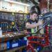 Francesco Ramon, a Venezuelan migrant who’s been working as a bike technician since June, works on a bike at one three workshops at Working Bikes located in Little Village, Wednesday, Oct. 9, 2024.