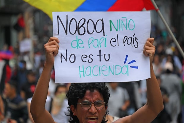 Un manifestante sostiene un cartel durante una protesta contra la extensión de los cortes de energía a 14 horas diarias, en Quito, el 31 de octubre de 2024. (Foto de Rodrigo BUENDIA / AFP)