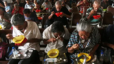 Getty Images Venezuelans eating food provided by church volunteers