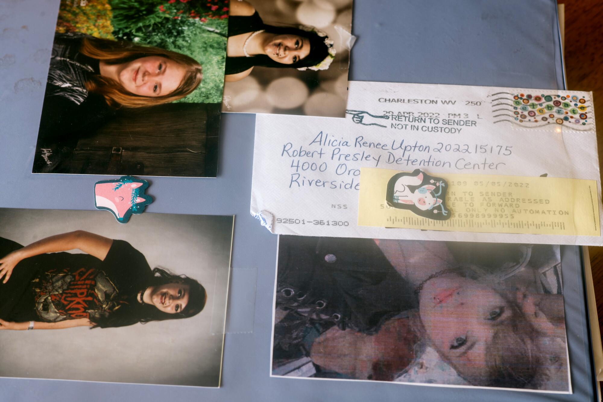 A letter with a yellow return label sits on a folder with photos of a young woman's childhood.