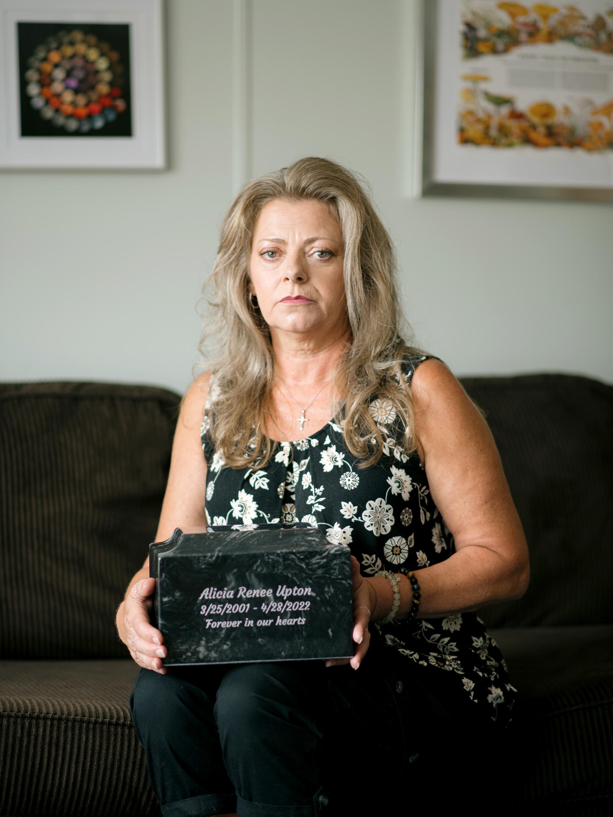 A woman holds a cremation urn.