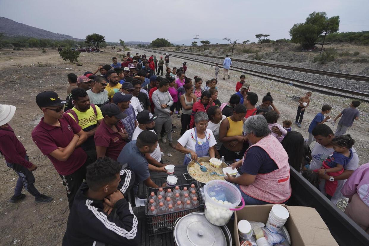 A group of nuns distribute food to migrants resting along the train tracks in Huehuetoca, Mexico.