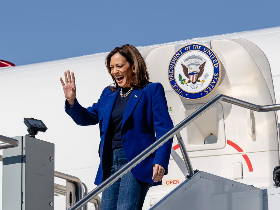 Kamala Harris waves while disembarking Air Force Two ahead of an afternoon campaign rally at Phoenix Sky Harbor Airport on October 31, 2024