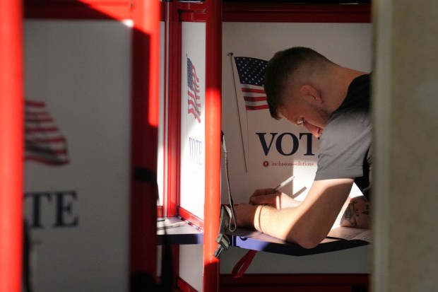 A voter fills out their their ballot during early voting in the general election