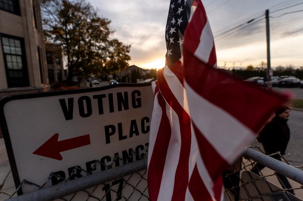 An American flag flies in the wind as a voter...