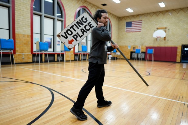 Election day worker Sean Vander Waal prepares to open a...