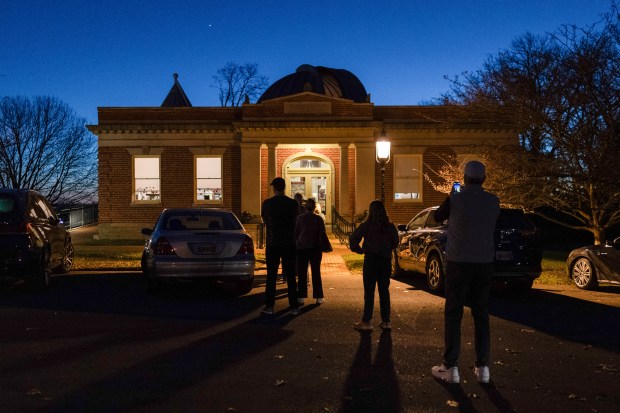 Voters line up to enter their polling place at the...