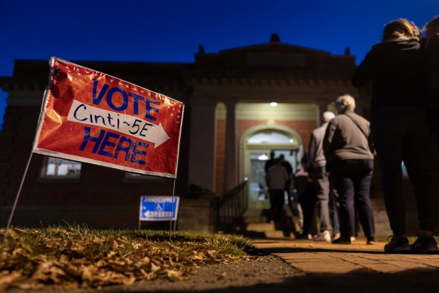 Voters line up to enter their polling place at the...