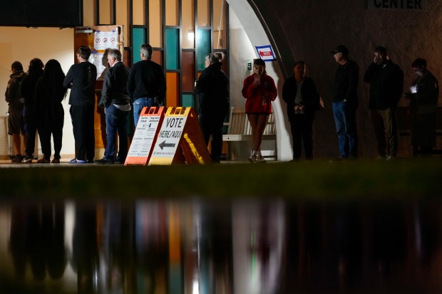 Voters stand in line outside a polling place at Madison...