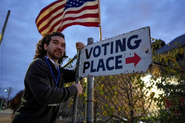 Election day worker Sean Vander Waal prepares to open a...