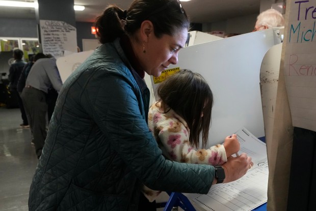 Vesta Avery, 2, helps her mother Alexis Taylor mark her...