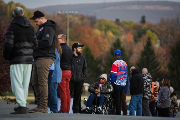 Liza Fortt, 74, center, waits in line to cast her...