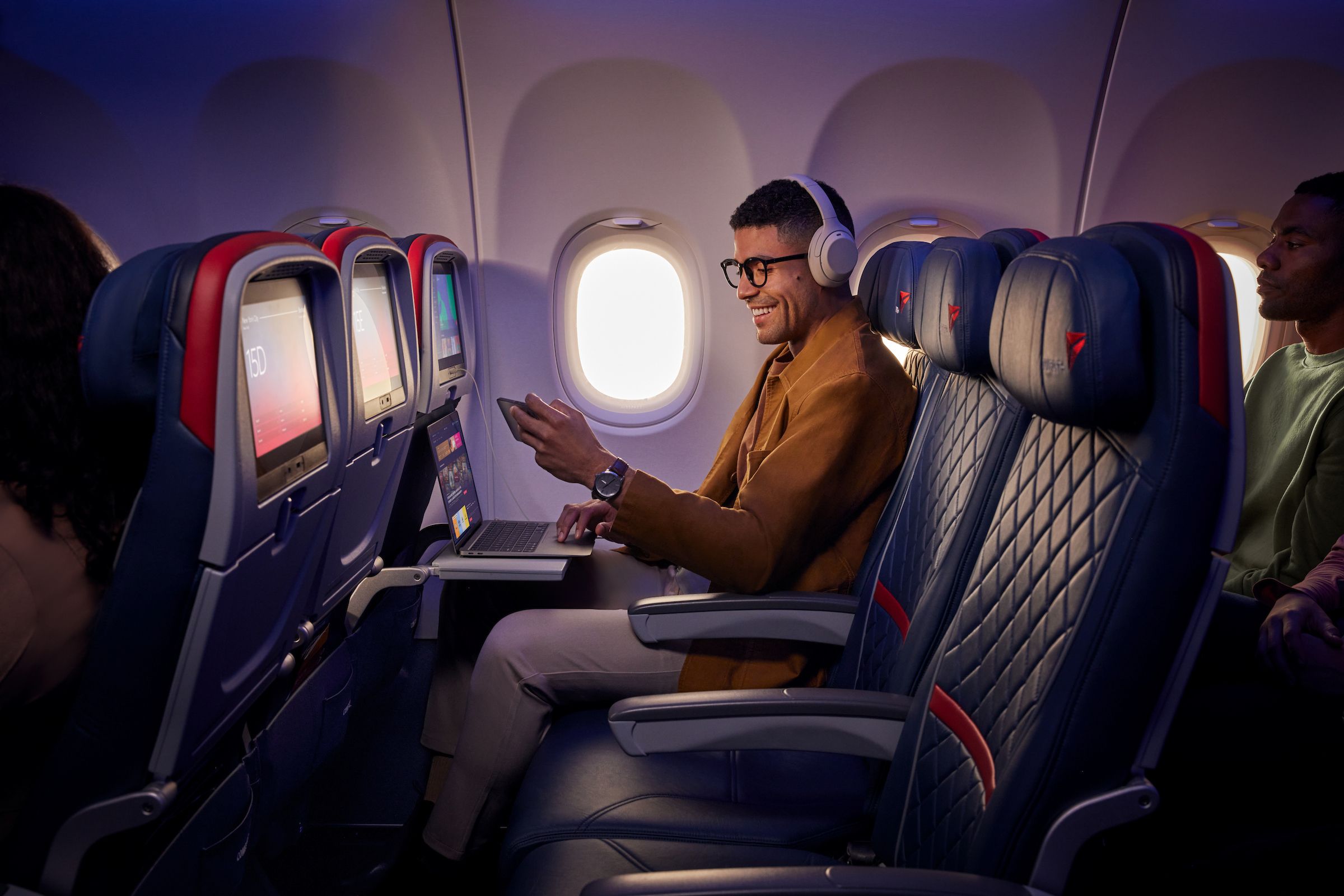 A passenger checks his phone on a Delta Air Lines plane