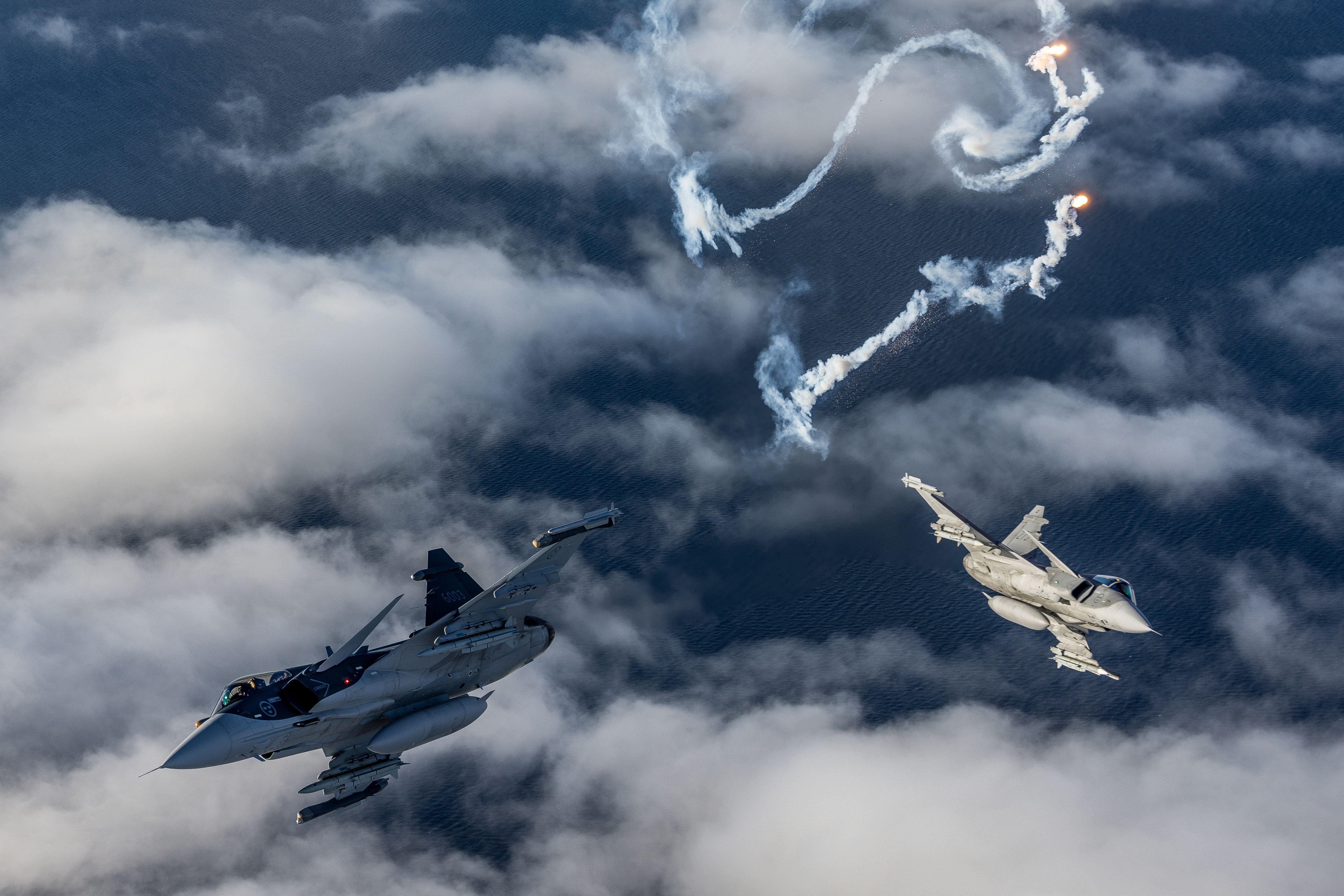 AIrtoAir_231107_ERK2064 (1) - Gripen E and Gripen C two-ship - two different models of 1-seat Saab JAS-39 Gripen fighter jets, and popping flares too