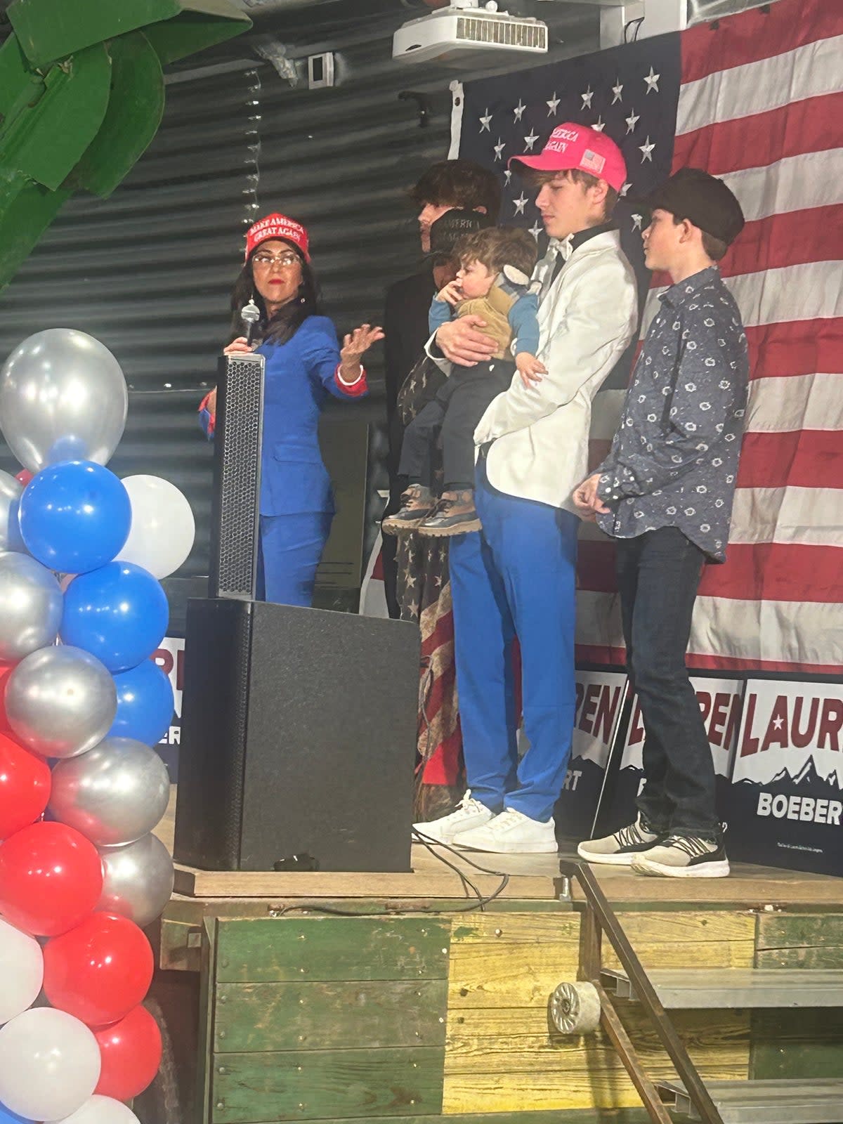 Boebert invited her mother and three of her sons, one of them holding her baby grandchild, onto the stage as she claimed victory on Tuesday (Sheila Flynn/The Independent)