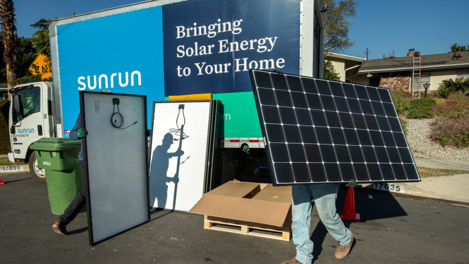 Workers prepare to install Sunrun solar panels on the roof of a home in Granada Hills, California.