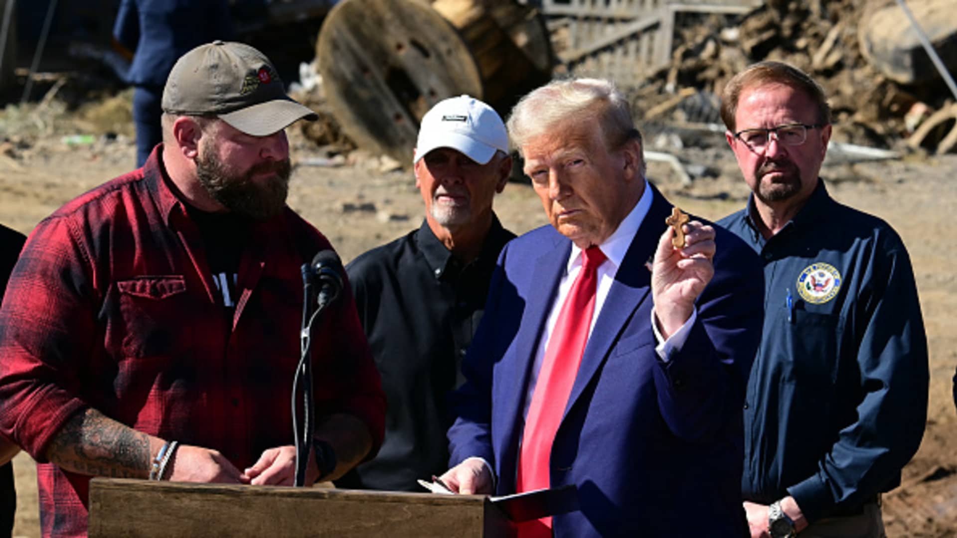 Former US President and Republican presidential candidate Donald Trump holds up a gift he received from local residents as he speaks to the media in Swannanoa, North Carolina, on October 21, 2024, after observing cleanup efforts in the aftermath of Hurricane Helene, which devastated the region. 