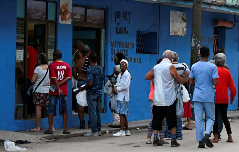 People line up at a bakery in Havana ahead of the arrival of Hurricane Rafael