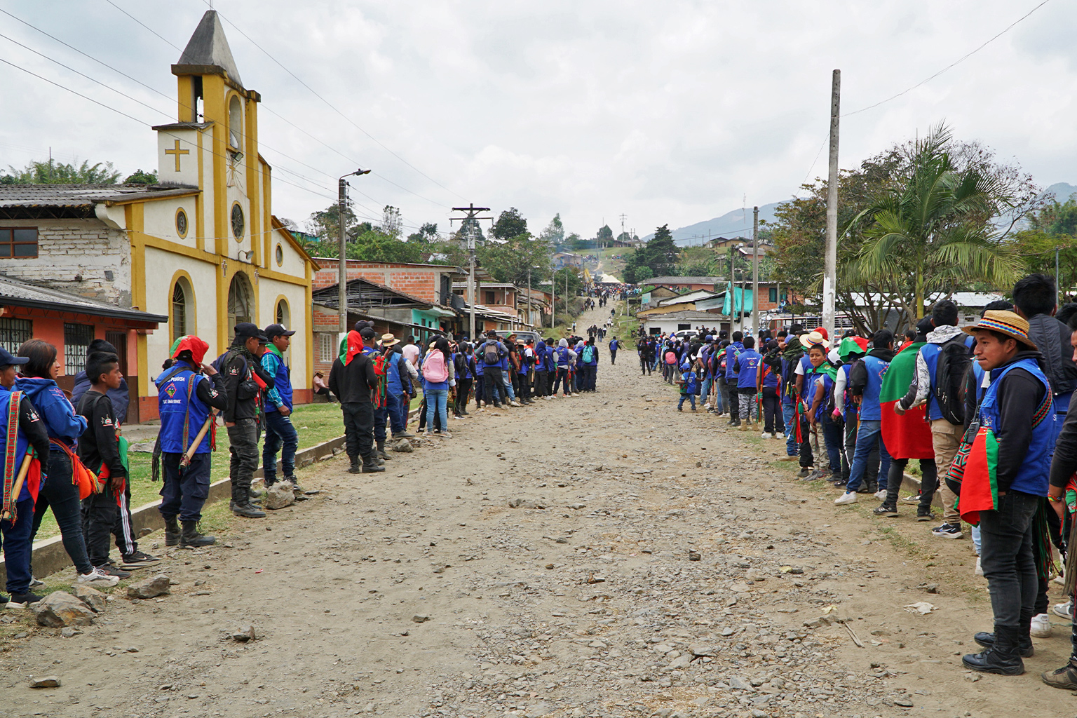 Members of the Indigenous Guard, carrying batons, line the streets of Pueblo Nuevo, accompanying Carlos on his final journey to his grave.