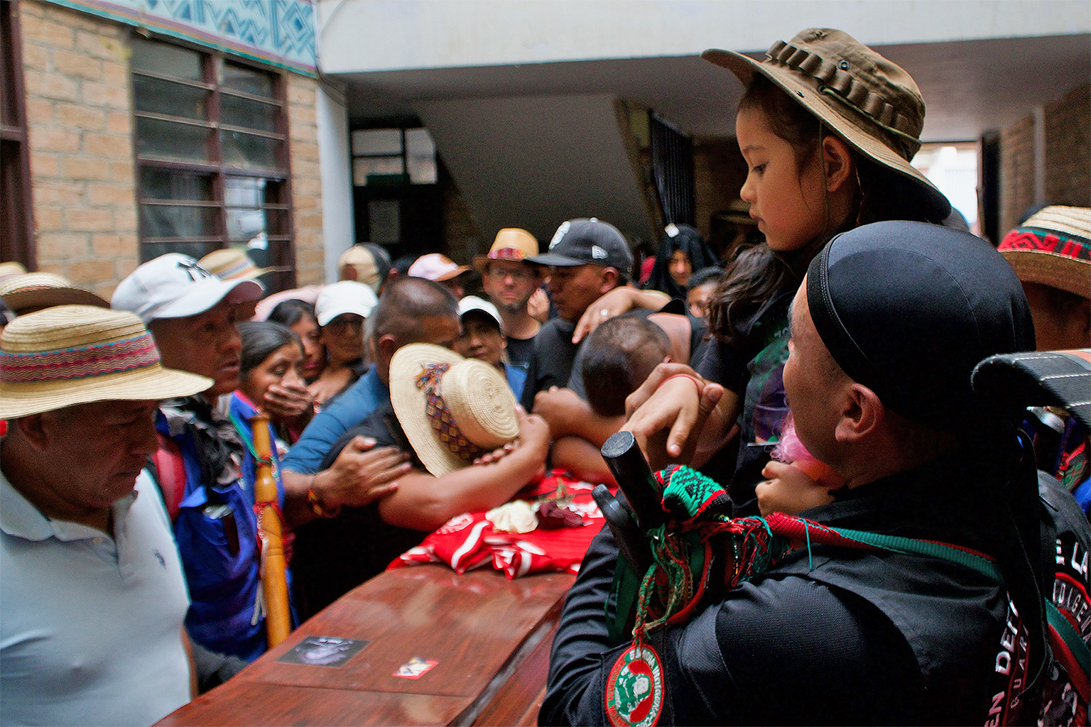 : Carlos’ daughter watches her father before he is buried, while his parents cry beside the coffin.