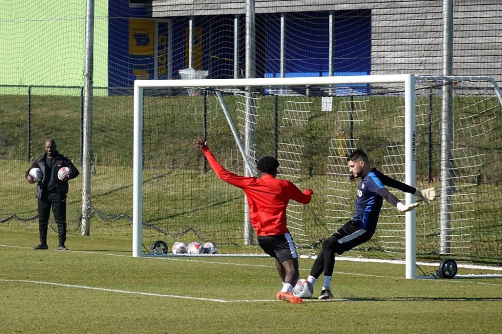 A staff member looks on as goalkeeper James Pantemis, right, makes a save on teammate Stephen Afrifa during practice for Canada's men's national team in Toronto, Thursday, Nov. 7, 2024. THE CANADIAN PRESS/Neil Davidson