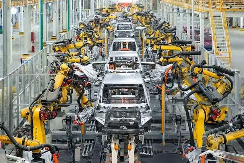 A line of BYD car frames on an assembly line featuring robotic arms on either side
