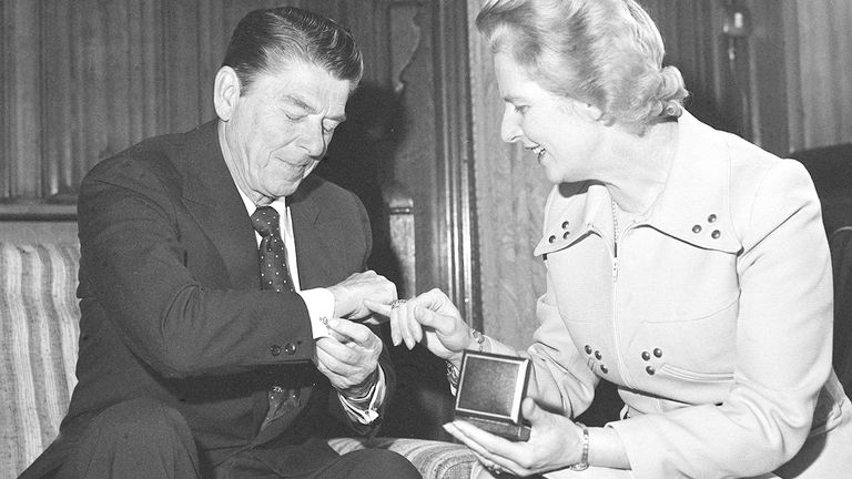 Margaret Thatcher admiring Ronald Reagan's bear design silver cufflinks when the former California Governor visited her office.  She is holding a silver dollar medallion presented to her by Mr Reagan.