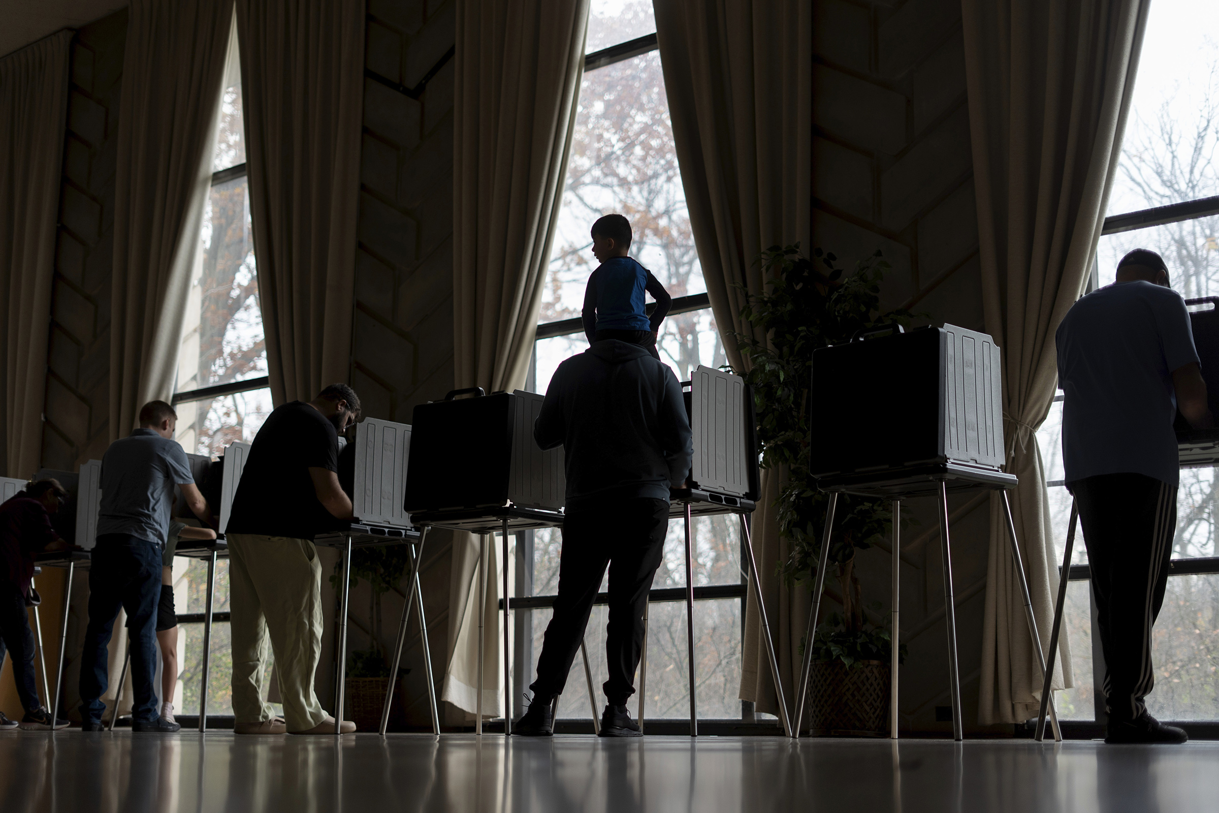 Three-year-old Zayn sits on his father's shoulders as he votes at the First Presbyterian Church of Dearborn in Mich., on Nov. 5, 2024.